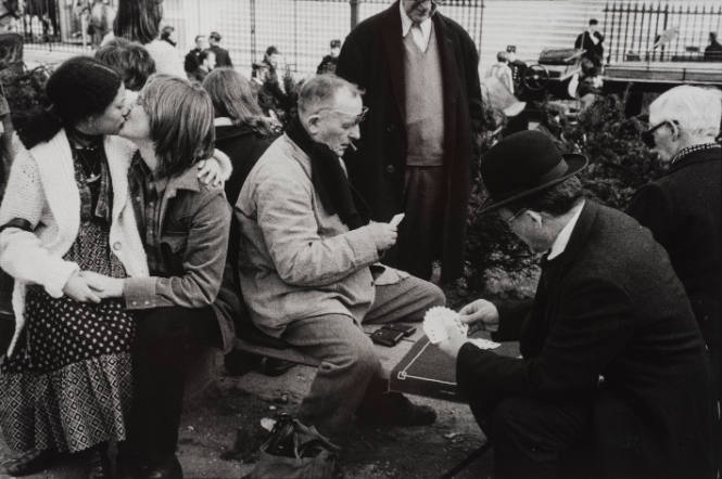 Two men playing cards while a young couple kissing beside, Paris, France