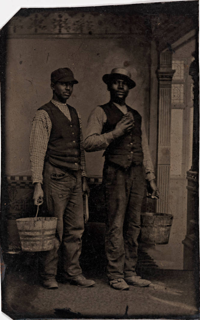 Two Black Men Wearing Vests and Holding Buckets