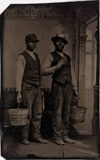 Two Black Men Wearing Vests and Holding Buckets