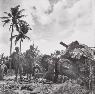 Wrecked Japanese tank inspected by troops moving inland, Philippines