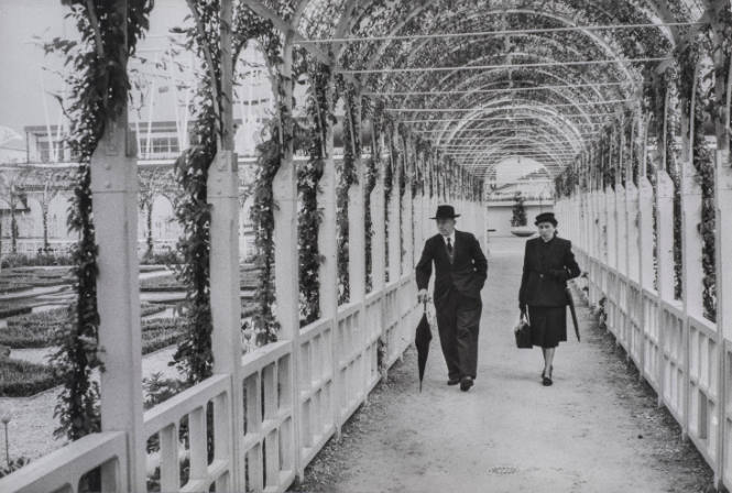Couple walking around trellised garden, Brussels World Fair