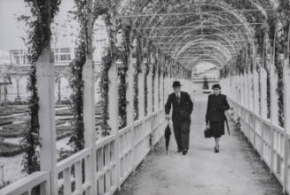 Couple walking around trellised garden, Brussels World Fair