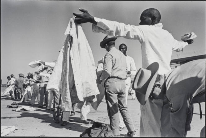 Shakedown (man being frisked, officer bending down behind him), from Conversations with the Dead: Photographs of Prison Life with the Letters of of Billy McCune #122054, 1971