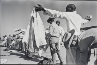 Shakedown (man being frisked, officer bending down behind him), from Conversations with the Dead: Photographs of Prison Life with the Letters of of Billy McCune #122054, 1971