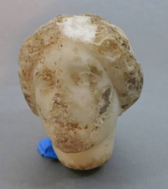 Head of a woman with rolled coiffure, headband, chignon at nape of neck