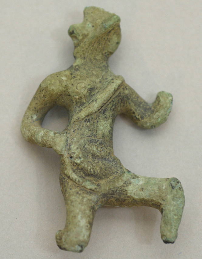 Warrior in archaic running pose (left knee lifted); wearing greaves, helmet and sword strap, hole for spear