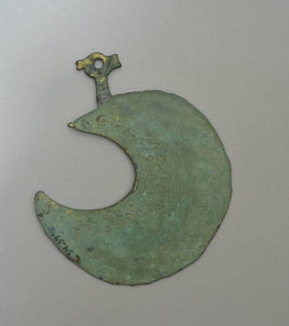 Lunate razor with stamped circles and Christian symbol incised on back, and bird's head attachment