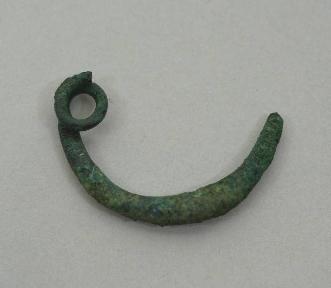 Fibula of simple bow type, ornamented with seven groups of fine incised lines