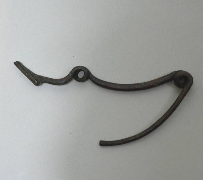 Fibula of simple type; single spirals, rectangular in section, at end and in middle of bow, bow with incised lines