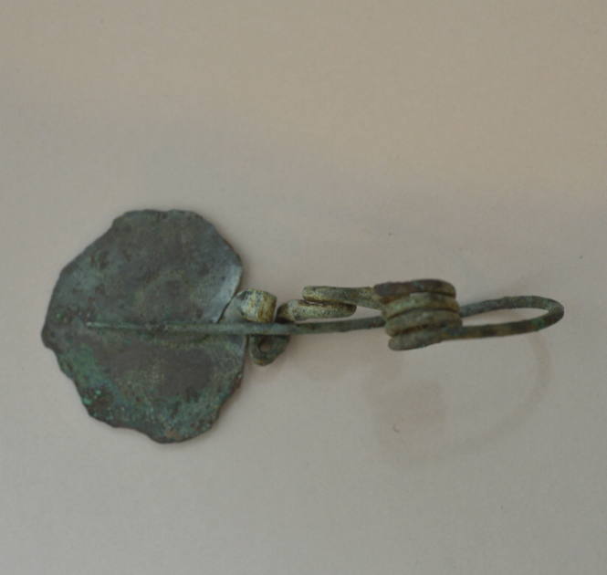 Fibula, elaborate type, with clasp of flattened bronze ornamented with incised patterns; quadruple spiral spring