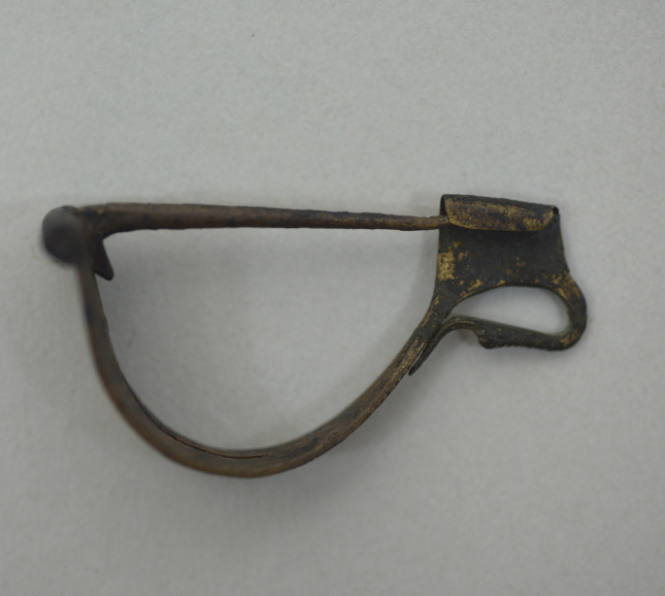 Fibula with simple bow, perforated, decorated with longitudinal rope pattern