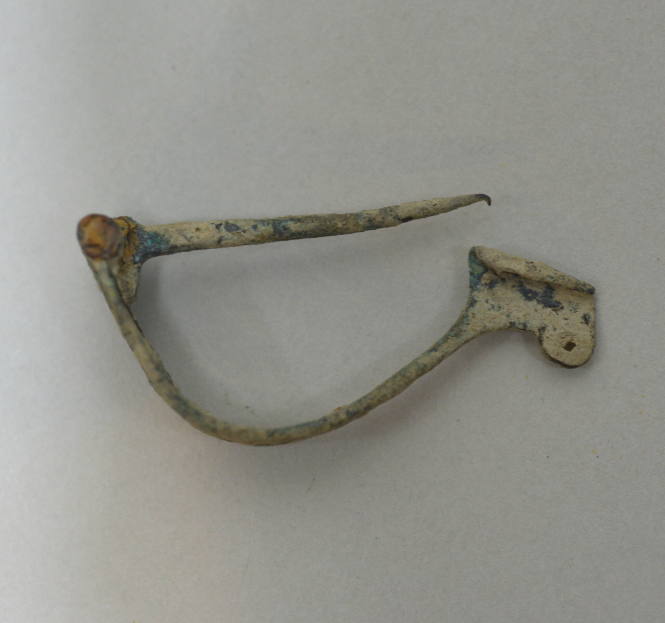 Fibula with laminate bow, pierce with three perforations; hinged pin