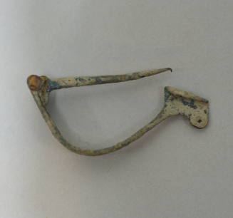 Fibula with laminate bow, pierce with three perforations; hinged pin