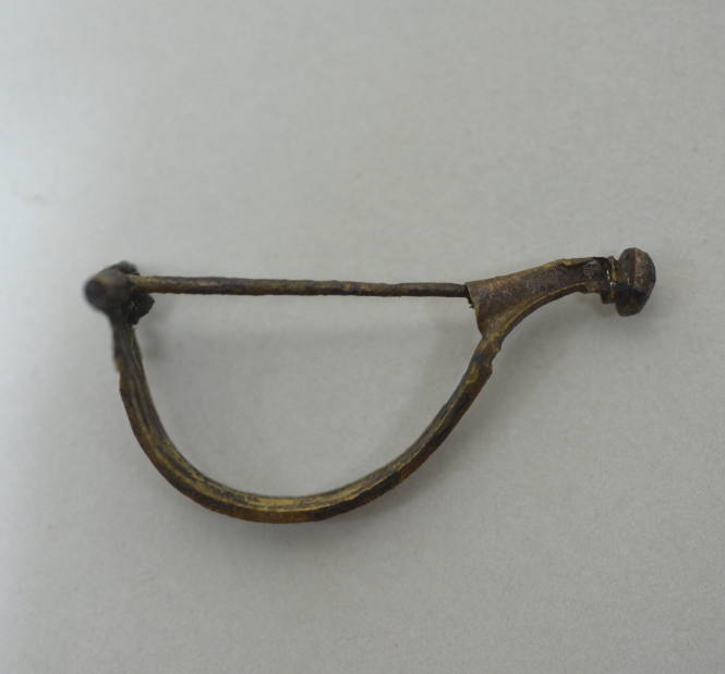 Fibula with hinged pin, ridged bow, knob at end of catch