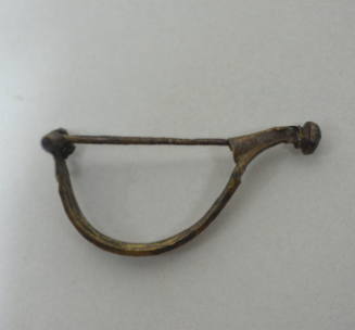 Fibula with hinged pin, ridged bow, knob at end of catch