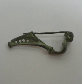 Fibula of Certosa-type, with eight spirals at spring, and knob at end of catch; catch perforated with four holes