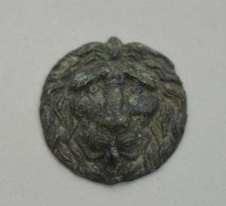 Circular applique with head of a lion in relief
