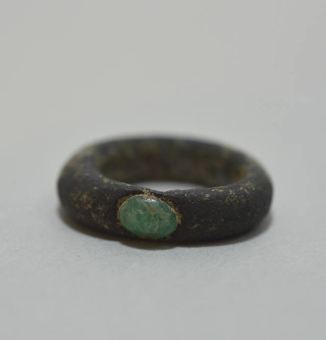 Finger ring with an inlaid green stone