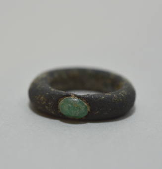 Finger ring with an inlaid green stone