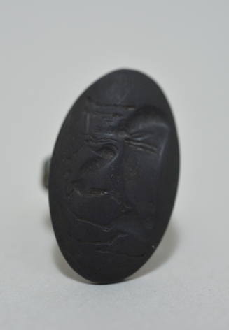 Ring with large bezel, molded in relief with anibex sheckling its youth