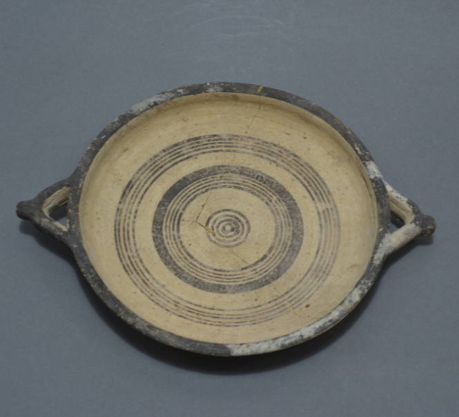 Flat plate white painted ware decorated with circles in brown (interior) and red and brown (exterior); lateral handles