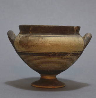 Cup, piriform on high foot, with lateral handles and painted decorative bands in brown and red