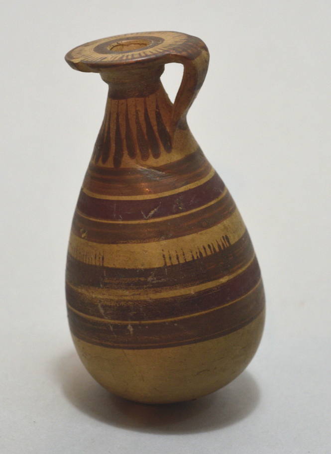 Italo-Corinthian sack alabastron with black and red linear encircling bands, and rays on shoulder
