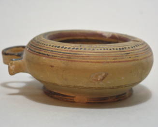 Italo-Corinthian bowl of ring-like form with lateral handle, decorated with dots and bands