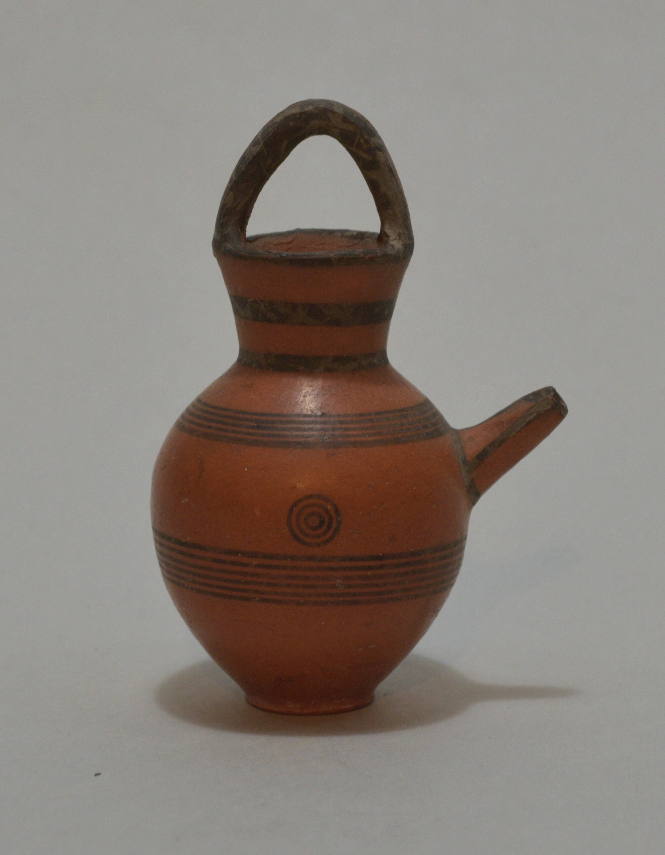 Spouted jar with strap handle and linear and concentric ornament