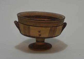 Kylix with high foot with concentric decoration in black and red, with swastikas
