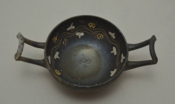Apulian kylix with lateral wishbone handles; interior decorated with vine scroll and stamped palmette