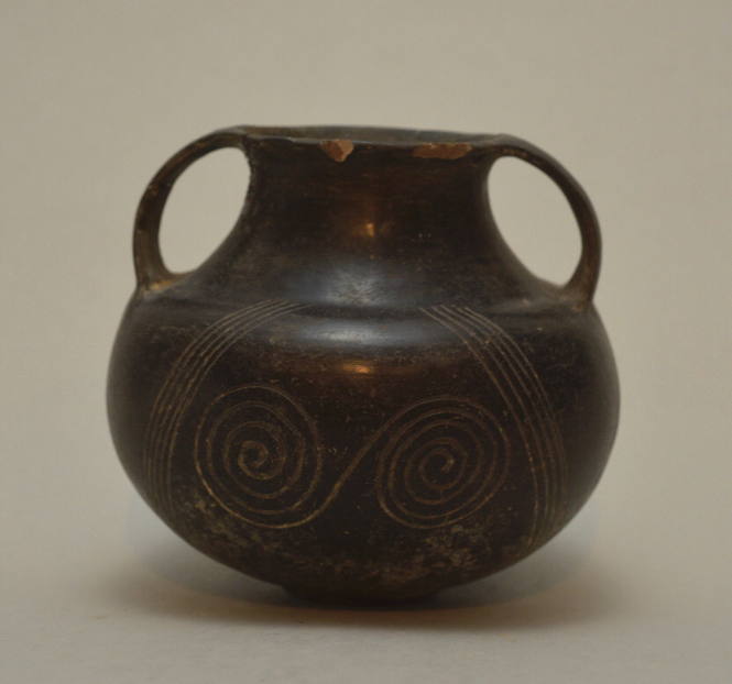 Villanovan double-sided handled jar; incised with double spirals on both sides, flanked by parallel zig-zag lines