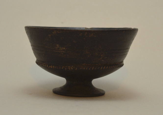 Etruscan bucchero "chalice" on low fot, with three incised encircling bands, and a band of notched ridges