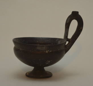 Etruscan bucchero cup with pedestal foot and high handle