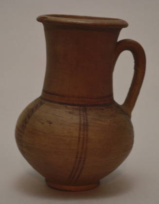 Jug with ring base, rounded body, strap handle, and a wide cylindrical neck with flaring rim