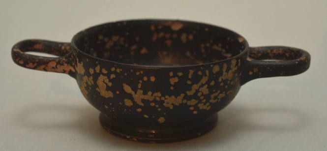 Black-glaze miniature kylix; four radical palmetts in interior