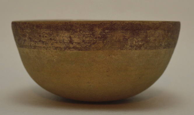 Pottery bowl with round base and band of red glaze around rim