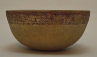 Pottery bowl with round base and band of red glaze around rim