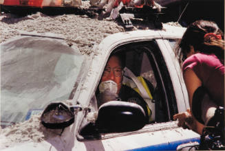 [Policeman in ash-laden patrol car]