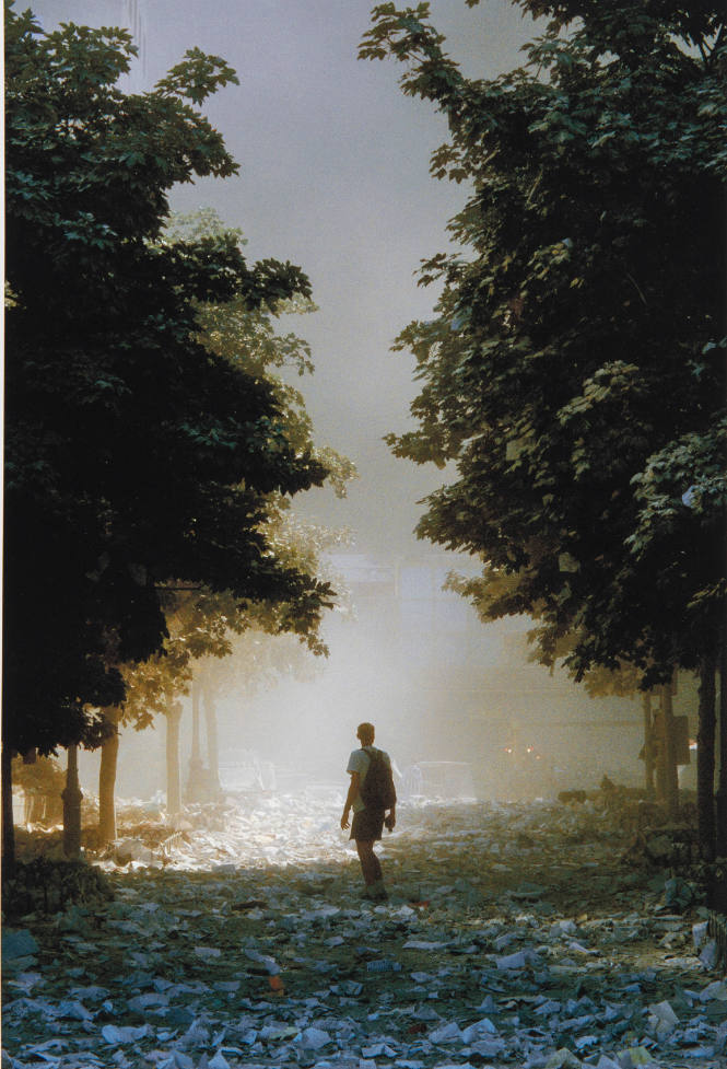[Man with rucksack amid scattered papers]