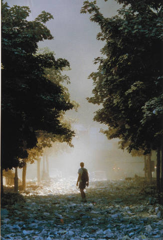 [Man with rucksack amid scattered papers]