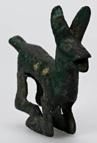 Yoke ornament of a crouching animal with mouth open, leaning forward